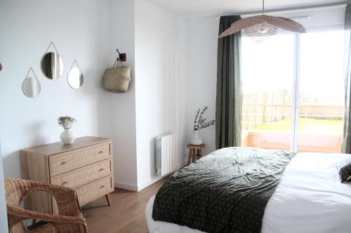 une chambre avec un lit, une commode et une fenêtre dans l'établissement La Madrague - front de mer, accès privé plage et place de parking, à Roscoff