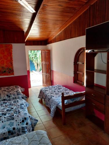 1 dormitorio con 2 camas y TV. en Las cabinas del sueño, en Nicoya
