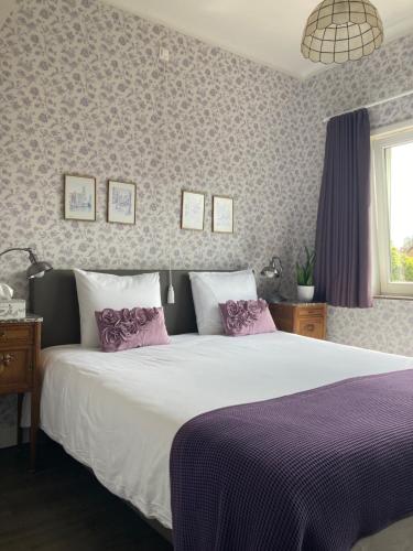 a bedroom with a large bed with purple sheets at Tree & B in Bruges