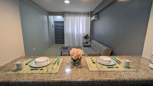a kitchen with a table with plates and flowers on it at Suite 618 Downtown Guayaquil- Centro de la Ciudad in Guayaquil