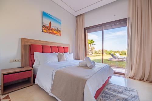 um quarto com uma cama grande e uma janela grande em Mandar Atlas em Marrakech