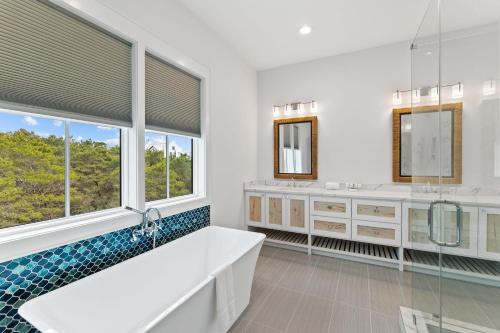 a bathroom with a tub and two sinks and windows at Seven Palms Pinnacle in Inlet Beach
