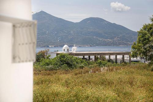 a house with a view of the water and a mountain at Christina Rooms in Adamas