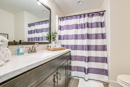 ein Badezimmer mit einem Waschbecken und einem lila Duschvorhang in der Unterkunft Modern Kentucky Lake Home with Deck, Dock, View in New Concord