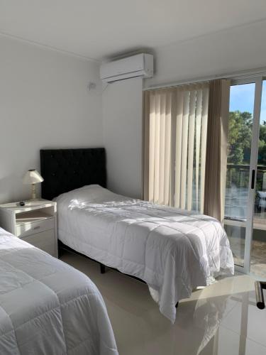 a bedroom with two beds and a window at Veneto Village J in Cordoba