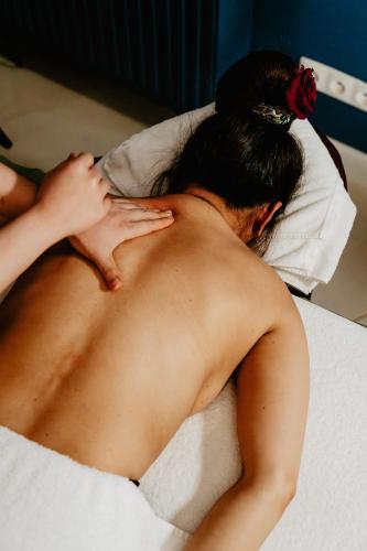 a naked woman laying on a bed with a pillow at Aroma Stone Hotel Spa in Syców