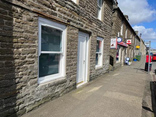 a brick building with a window on a street at Old chemist in Lybster