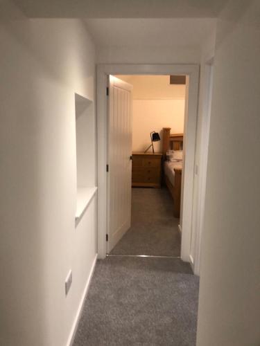 an empty room with a hallway with a bed and a door at Old chemist in Lybster