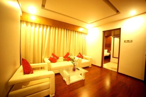 a living room with two white couches and a table at Olive Downtown in Cochin