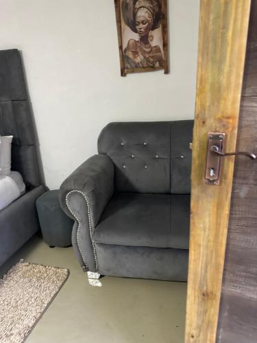 a gray couch in a living room with a picture on the wall at Beach View B&B in East London