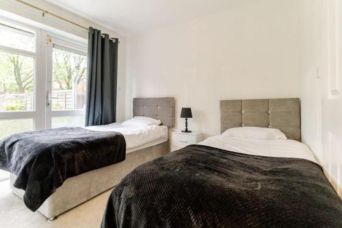 2 łóżka w sypialni z oknem w obiekcie A&S Properties, No guest fees, Bank transfe deposit available w mieście Fallings Park