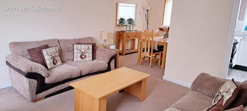 a living room with a couch and a table at Curlew - Port Seton in Port Seton