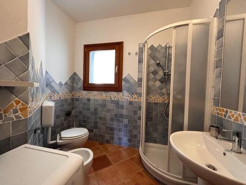 een badkamer met een toilet, een wastafel en een douche bij Casa vacanze - Le Bacche di Maiorca in Budoni