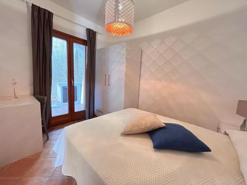 een slaapkamer met een wit bed en een blauw kussen bij Casa vacanze - Le Bacche di Maiorca in Budoni