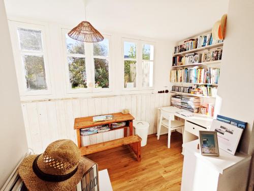 Cette chambre comprend un bureau, une table et des étagères. dans l'établissement Ker Gwelika - Maison familiale, à Carantec