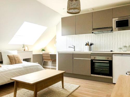 Il comprend une cuisine et un salon avec un lit et une table. dans l'établissement Le Zen - Superbe logement - Centre - Tram - Gare, au Mans