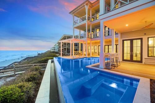 a house with a swimming pool next to the ocean at Del Mar in Seacrest