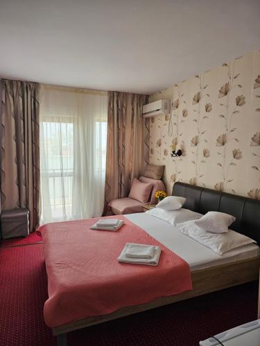 a bedroom with a large bed with a red blanket at Casa Amiral in Sulina