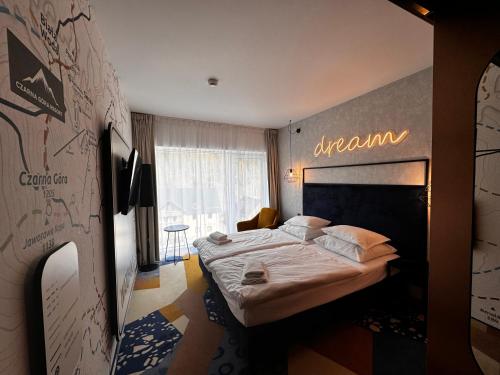 ein Schlafzimmer mit einem Bett mit einem Schild an der Wand in der Unterkunft Czarna Góra Biała Perła EnergyApart in Heudorf