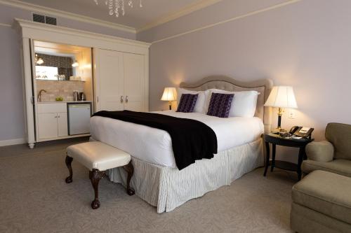 ストラトフォードにあるThe Bruce Hotelの大きなベッドと椅子が備わるホテルルームです。