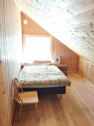 a bedroom with a bed and a chair in a room at Great house in Risør centre in Risør