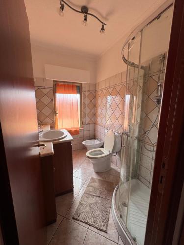 a bathroom with a toilet and a sink and a shower at Romagnosi apartment in Porto Torres