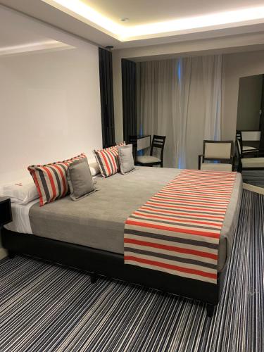 a bedroom with a large bed with a striped blanket on it at Benjamín I in San Salvador de Jujuy