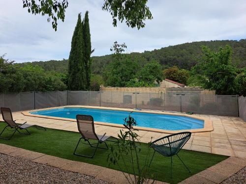 - une piscine avec deux chaises dans la cour dans l'établissement Villa les fauvettes, à Cabasse