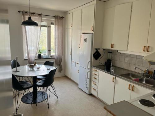 a kitchen with a table and chairs and a refrigerator at Johnericssonsväg Apartment Malmö in Malmö