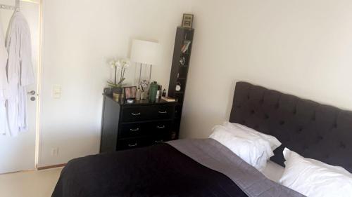 a bedroom with a black bed and a black dresser at Johnericssonsväg Apartment Malmö in Malmö