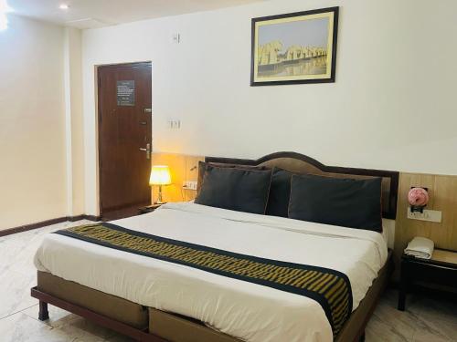 Royal Presidency Inn في لاكناو: غرفة نوم بسرير كبير في غرفة