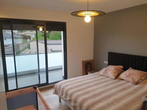 マコンにあるlocation villa moderne piscineのベッドと大きな窓のある寝室