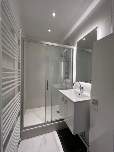 ein weißes Badezimmer mit Dusche und Waschbecken in der Unterkunft Paris Serenity Bedroom [Female guest only] in Courbevoie