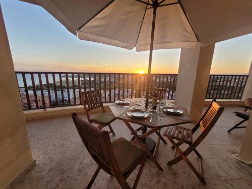 a table with chairs and an umbrella on a balcony at O WOW View Portimao, ALvor, ALGARVE in Portimão