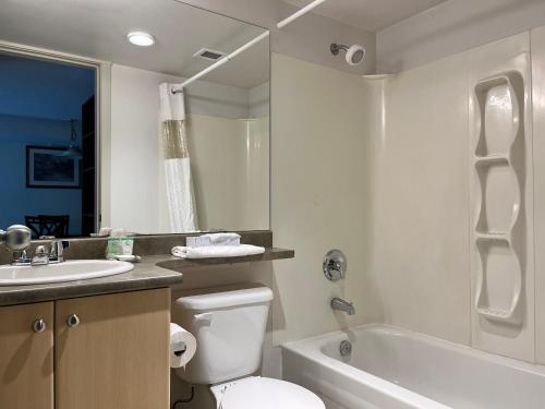 a bathroom with a toilet and a sink and a bath tub at Carey Centre in Vancouver