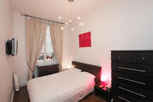 Un dormitorio con una cama y una cómoda y una ventana. en Royal Versailles Dolcevita St Louis, en Versalles