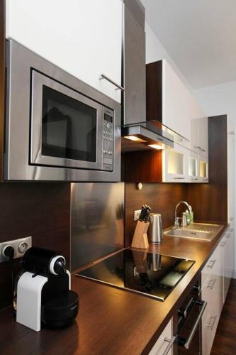 une cuisine avec un comptoir avec un micro-ondes dans l'établissement Royal Versailles Dolcevita St Louis, à Versailles