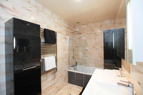 Un baño con bañera, lavabo y bañera. en Royal Versailles Dolcevita St Louis, en Versalles