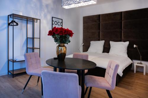 1 dormitorio con 1 cama y 1 mesa con rosas rojas en Wohngut-Appartement 50qm 2, Zimmer für max 5 Pers inklusive Parkplatz, en Hagen