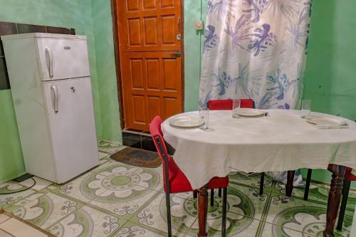 a table with two chairs and a white refrigerator at SMITH'S BNB ROOMS in Georgetown