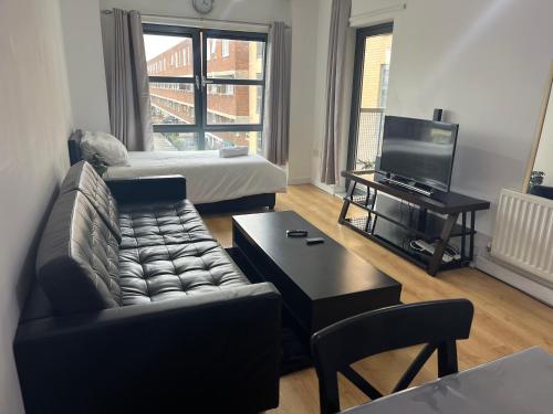 ein Wohnzimmer mit einem Sofa, einem Bett und einem TV in der Unterkunft London Luxury Holiday Home B in London