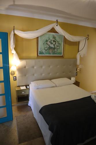 Un dormitorio con una cama blanca y una pintura en la pared en Amoreira Pousada em Barra Grande Piaui en Barra Grande