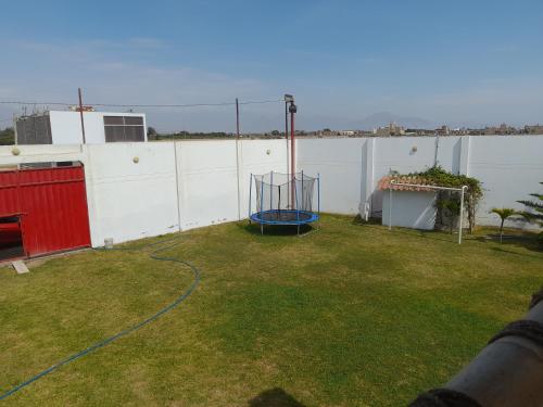 a backyard with a basketball hoop in the grass at Villa Valentino in Trujillo