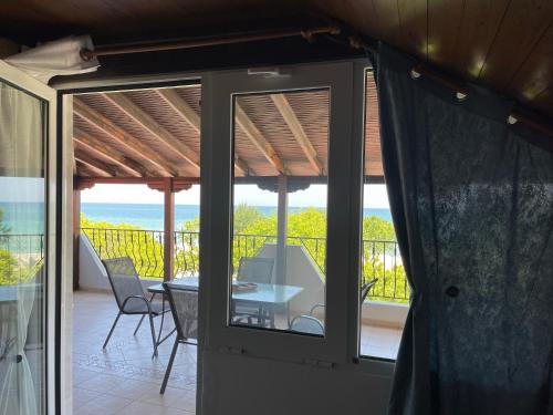 a patio with a table and chairs on a balcony at Indigo sea view rooms in Olympiaki Akti