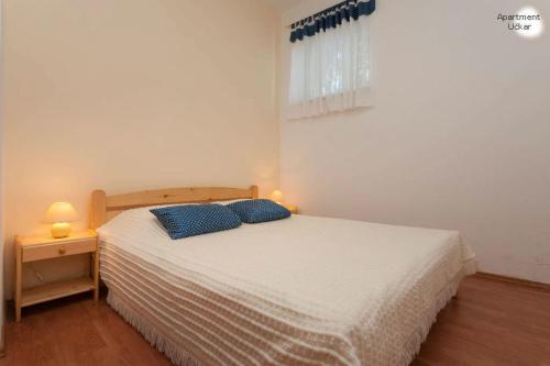 - une chambre avec un lit doté de 2 oreillers bleus dans l'établissement Apartment Uckar, à Barban
