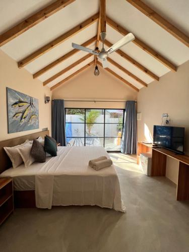 1 dormitorio con 1 cama grande y ventilador de techo en Manta Stay Thoddoo, Maldives en Thoddoo