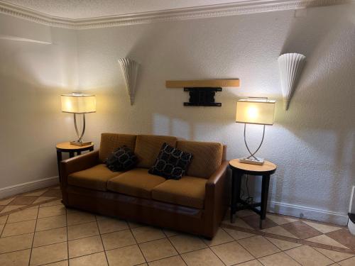 sala de estar con sofá y 2 lámparas en Boardwalk Suites Lafayette en Lafayette