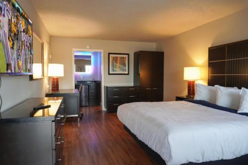 Habitación de hotel con cama y escritorio con lámparas en Boardwalk Suites Lafayette en Lafayette