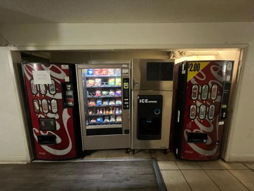 duas máquinas de refrigerante sentadas ao lado uma da outra em Boardwalk Suites Lafayette em Lafayette