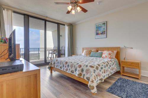 a bedroom with a bed and a tv and a balcony at Beachfront Dauphin Island Condo with 2 Pools and Sauna in Dauphin Island